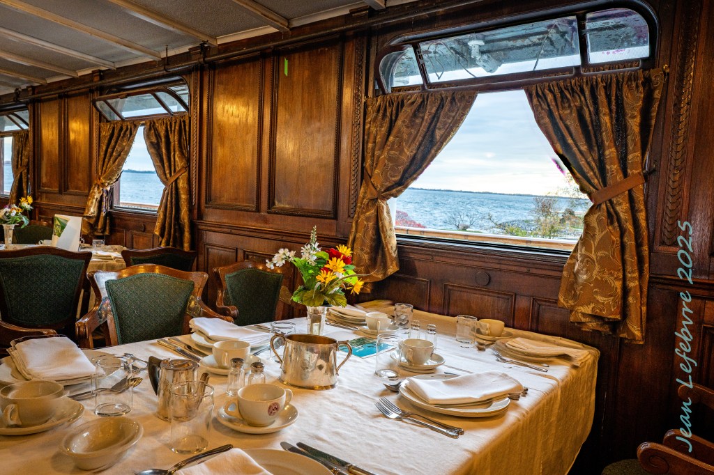 Fancy dining table with window looking out into the water.
